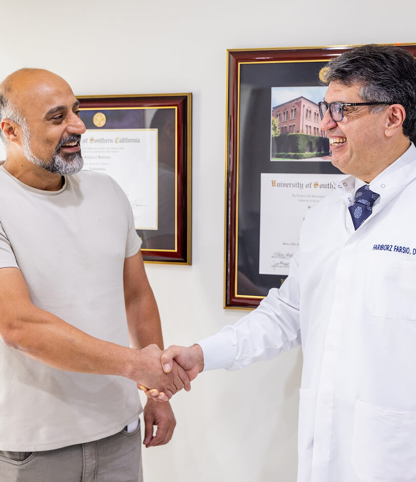 Dr. Farsio shaking hands with a patient